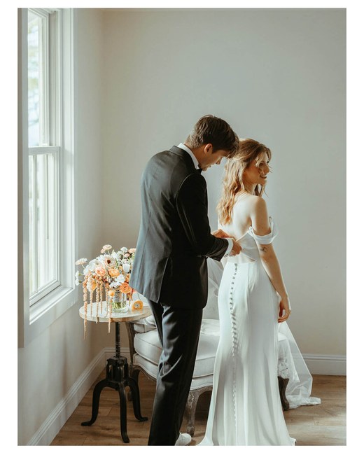 A groom buttons the bride's wedding dress, from the Love and Beauty Maui portfolio page on a phone